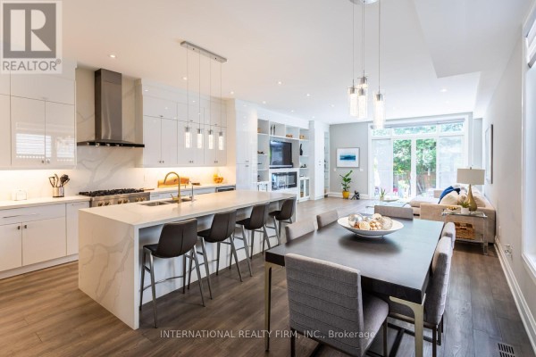 Modern kitchen with large island, white cabinets, and dining area - 36b Pine Avenue Mississauga
