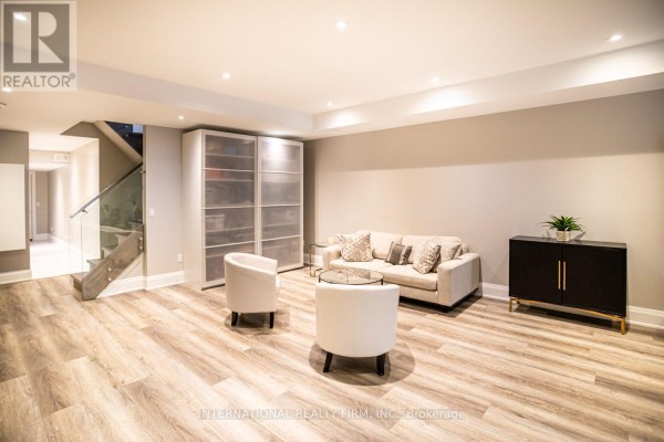Modern living room with sofa, chairs, and glass stairs - 36b Pine Avenue Mississauga
