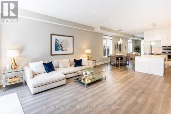 Modern sectional sofa, glass coffee table, and open-concept kitchen with island - 36b Pine Avenue Mississauga
