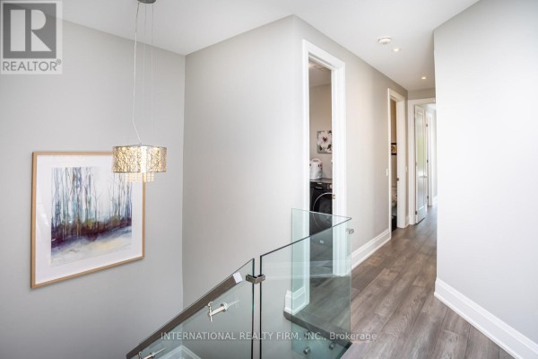 Modern hallway with glass railing and chandelier - 36b Pine Avenue Mississauga