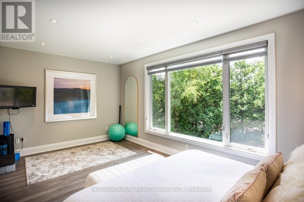 Bedroom with large window, exercise balls, mirror, artwork, and rug - 36b Pine Avenue Mississauga
