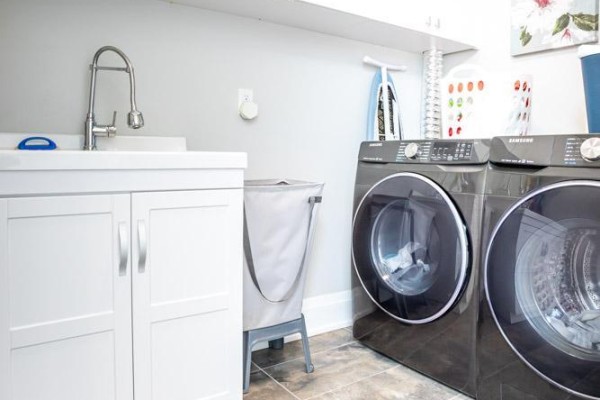 Modern laundry room with white cabinets, sink, and Samsung washer/dryer set - 36b Pine Avenue Mississauga