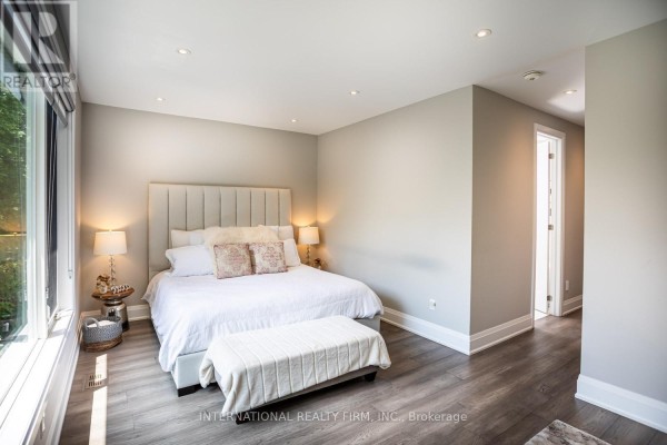 Bedroom with tufted headboard, bench, and large window - 36b Pine Avenue Mississauga