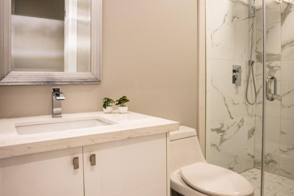 Modern bathroom with white vanity, vessel sink, large mirror, and glass shower with marble tiles - 36b Pine Avenue Mississauga