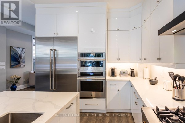 Modern kitchen with stainless steel appliances, white cabinets, and quartz countertops - 36b Pine Avenue Mississauga