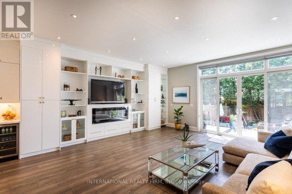 Living room with entertainment center, sofa, and glass doors - 36b Pine Avenue Mississauga