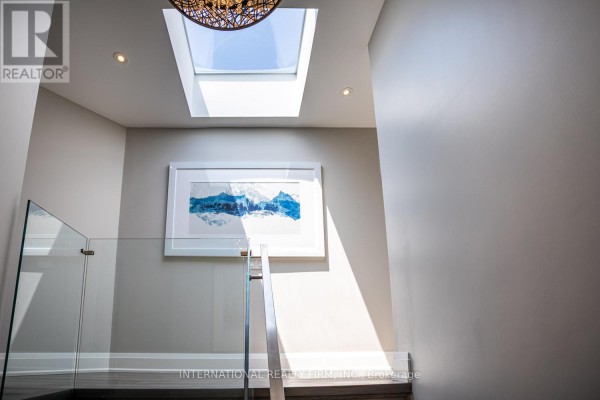 Modern hallway with skylight, glass railing, and art - 36b Pine Avenue Mississauga