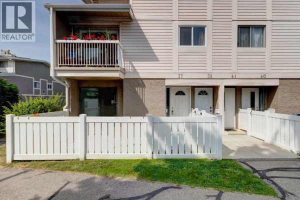 Front exterior of a beige townhouse complex with units numbered 37, 38, 41, and 40. - 37, 3015 51 Street Sw, Calgary