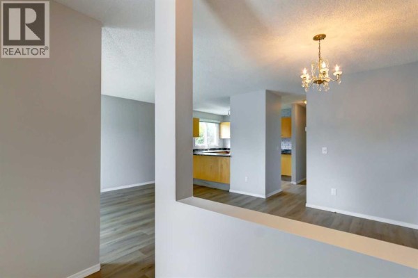 Interior view of a living area looking into a kitchen with light wood cabinets. - 37, 3015 51 Street Sw, Calgary