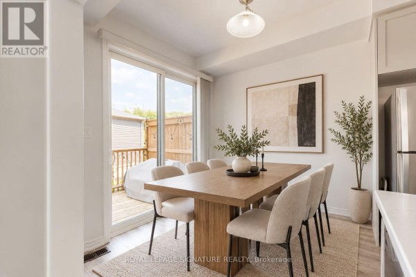 Dining area with a wooden table, upholstered chairs, and sliding glass doors to a deck. - 37 - 10 Birmingham Drive, Cambridge