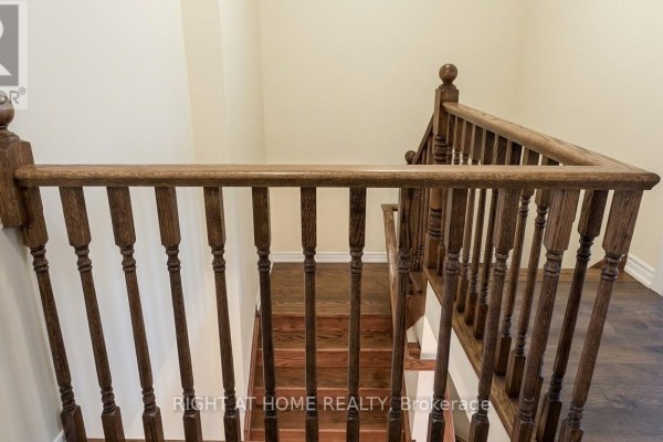 Wooden staircase with a dark wood banister and spindles leading to the second floor. - 37 - 19 Ridge Road, Cambridge