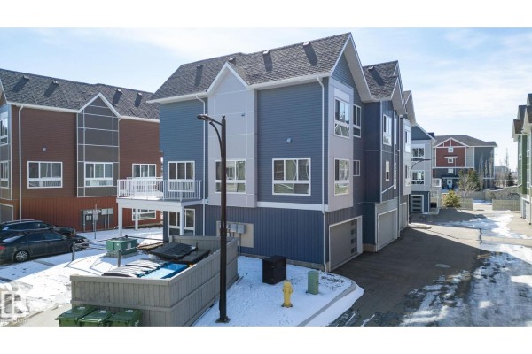 Aerial view of a row of townhouses with blue, gray, and red siding in winter. - #37 979 Crystallina Nera Wy Nw Nw, Edmonton