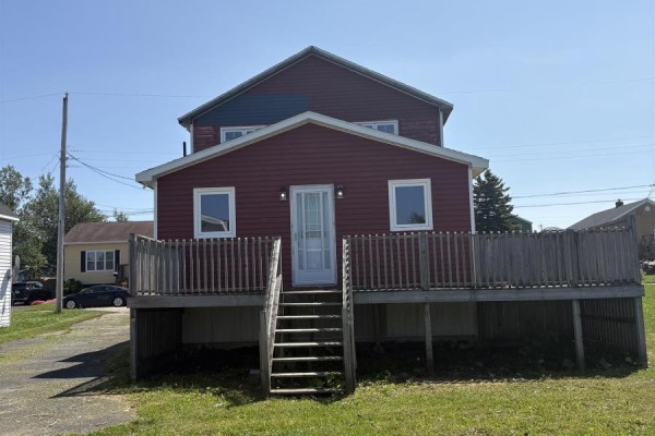 Rear of a red house with a white door, deck, and stairs. Driveway and car visible. - 37 Bennett Street, Grand Lake Road