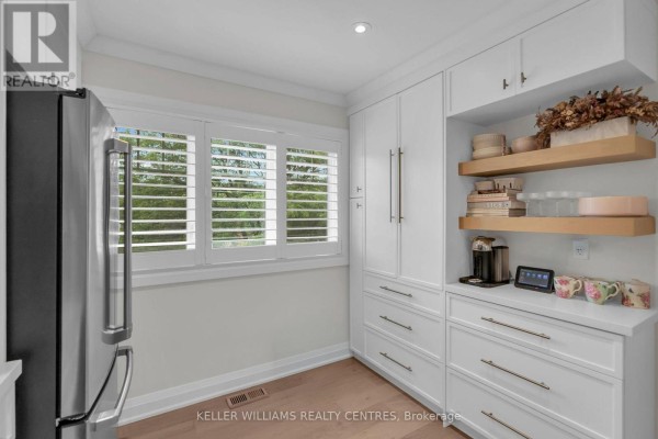 Kitchen pantry wall with white cabinets, open shelving, stainless steel refrigerator, and plantation shutters on window. - 37 Bowler Street, Aurora