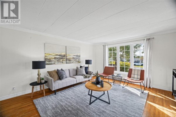 Living room with wood floors, white walls, and furniture including a sofa and chairs. - 37 Cedar Drive, Paradise