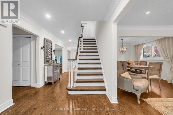 Entrance hall with a staircase, wood floors, dining area, and furniture. - 37 Gretman Crescent, Markham