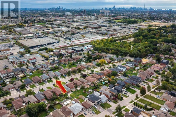 Aerial view of a residential neighborhood showing multiple single-family homes with green lawns. - 37 Jocada Road, Toronto