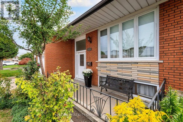 Entrance to the house with a white door, large windows, and a black metal railing. - 37 Jocada Road, Toronto