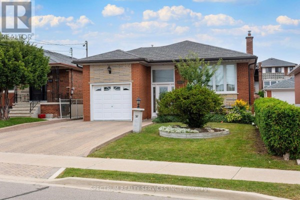 View of a brick bungalow with a manicured lawn, garden bed, and paved driveway. - 37 Jocada Road, Toronto