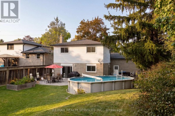 Backyard with an above-ground pool, patio with dining set, raised garden bed, and mature trees. - 37 Maple Avenue W, New Tecumseth