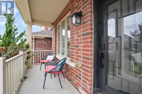 Porch seating area with two blue chairs and a small table next to the entrance. - 37 Mcgovern Street, New Tecumseth
