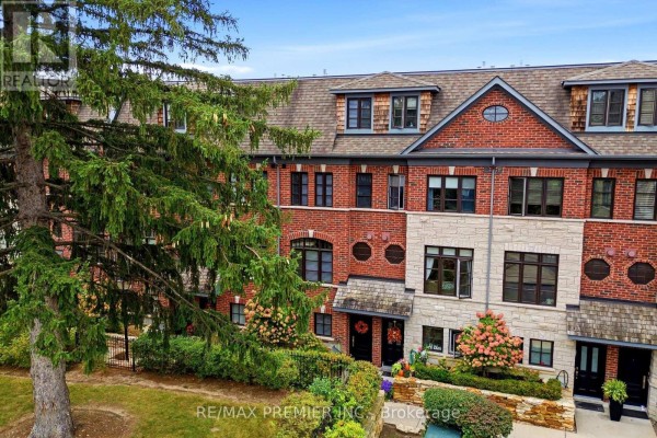 Aerial view of a brick townhouse complex with mature trees and landscaping in front. - 37 Nease Lane E, Vaughan