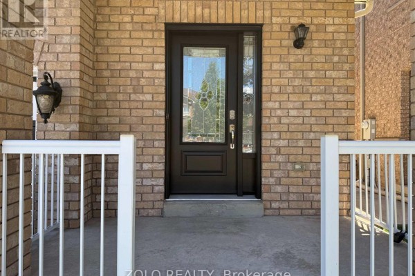 Close-up of the dark brown front door with decorative glass inserts and brick siding. - 37 Sewells Lane S, Brampton