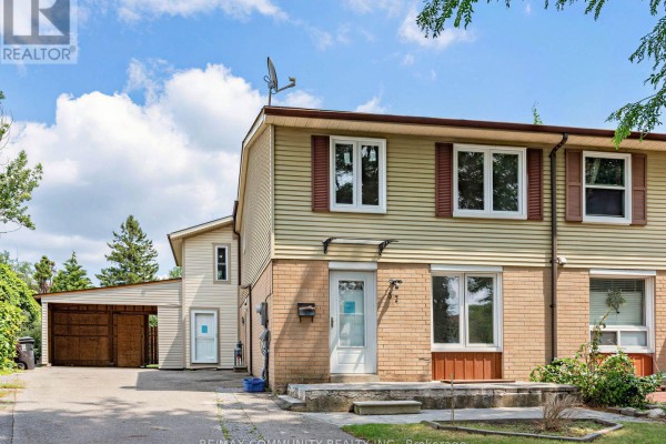 Front exterior of a two-story townhouse with brick and vinyl siding, front door, and windows. - 37 Tinbury Place, Toronto