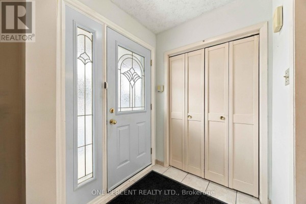 Interior view of the foyer with a front door and double closet doors. - 37 Wilmont Drive, Toronto