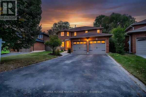 Exterior of a brick house at dusk with lights on and dramatic sunset sky. - 37 Wyndfield Crescent, Whitby