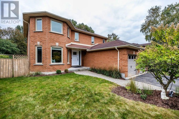 Front exterior of a red brick two-story house with a manicured lawn and walkway. - 37 Wyndfield Crescent, Whitby