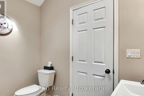 Toilet, sink, and wall clock in a bathroom - 370 6th Avenue Hanover