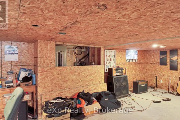 Guitars and amps in a room with unfinished wood paneling - 370 6th Avenue Hanover
