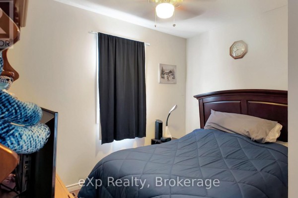 Bedroom with bed, nightstand, desk lamp, and clock - 370 6th Avenue Hanover