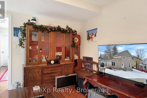 Living room with hutch, clock, and TV showing house exterior - 370 6th Avenue Hanover