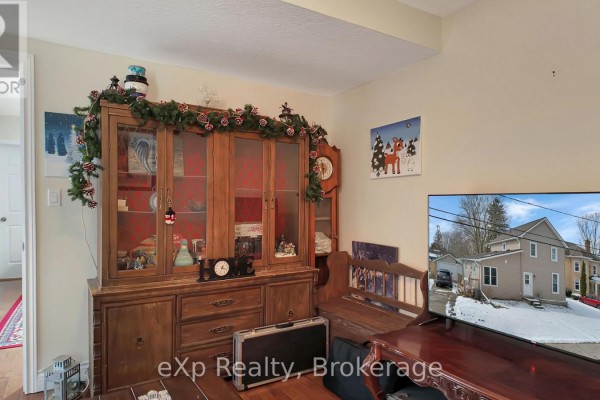 Wooden china cabinet, fireplace, and TV displaying house exterior - 370 6th Avenue Hanover