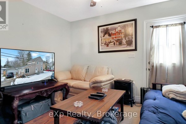 Living room with cream sofa, blue futon, TV, and artwork - 370 6th Avenue Hanover