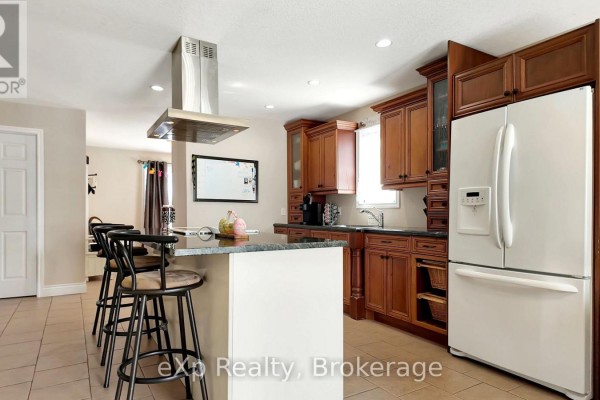 Kitchen with island, dark wood cabinets, and stainless steel hood - 370 6th Avenue Hanover