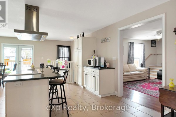 Kitchen island with seating and range hood, open to living room with couch - 370 6th Avenue Hanover