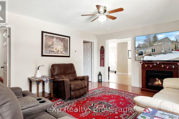 Living room with fireplace, mounted TV, recliner, sofa, and patterned rug - 370 6th Avenue Hanover