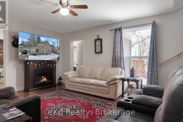 Living room with fireplace, TV, sofa, recliners, and red rug - 370 6th Avenue Hanover