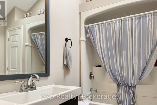 Bathroom with sink, mirror, and bathtub with striped shower curtain - 370 6th Avenue Hanover