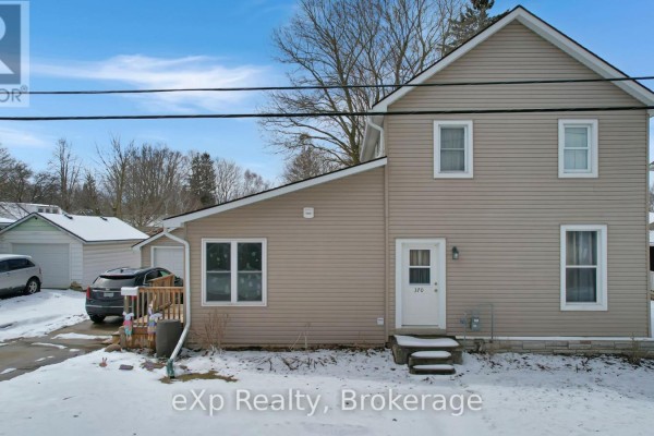 Tan house with white trim, white front door, and detached garage - 370 6th Avenue Hanover