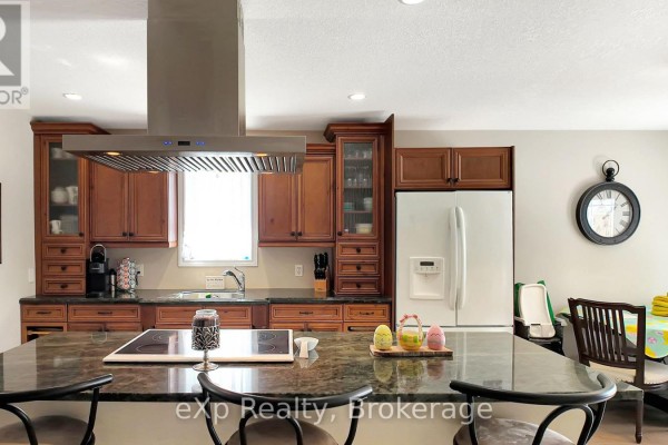 Kitchen island with stovetop, wooden cabinets, and dining area - 370 6th Avenue Hanover