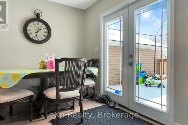 Dining room with table, chairs, clock, and doors to a snowy backyard with toys - 370 6th Avenue Hanover