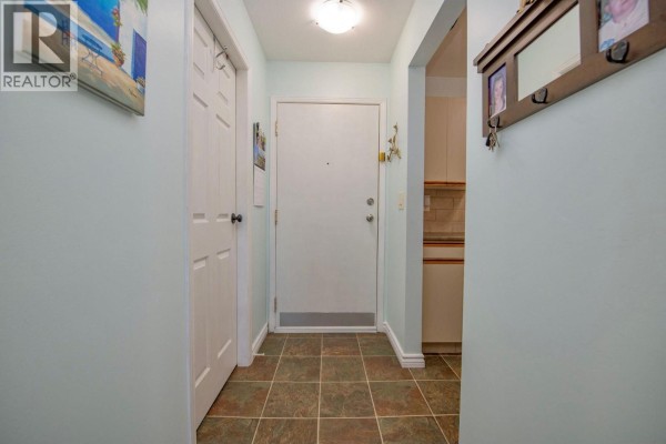 Interior entryway with light blue walls, tiled floor, and white door. - 3700 28a Street Unit# 319, Vernon