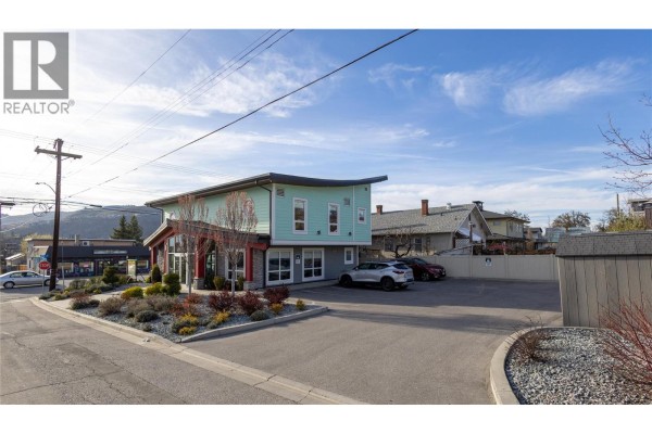 Exterior view of a light blue commercial building with a curved roof, large windows, and a parking lot. - 3701 27 Street, Vernon