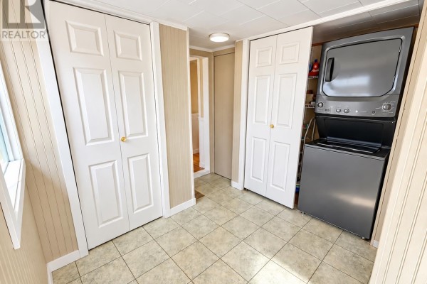 Interior view showing tiled floor, white doors, and a stacked washer and dryer. - 3702 North Carleton Road, Rte 10, Searletown