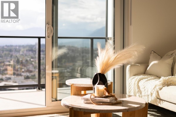 Close-up of coffee table with decorative items and view of cityscape through window. - 3707 2135 Springer Avenue, Burnaby