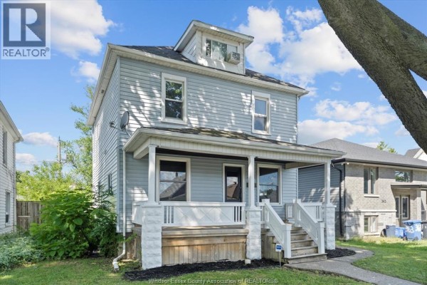 Side view from the right of a light blue two-story house with a covered porch. - 371 Curry, Windsor